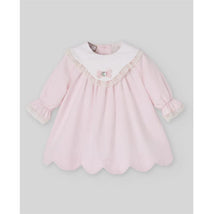 Light pink woven newborn dress with a white lace collar, small bow detail, and scalloped hem.