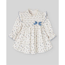 Woven newborn dress in cream with floral print, ruffled neckline, and blue bow detail. Perfect for infants.