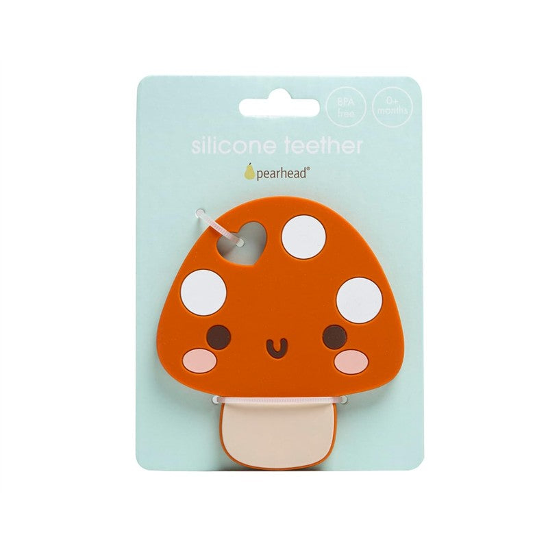 Orange mushroom-shaped silicone teether with white spots and a smiling face, packaged with a light blue background.