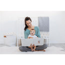 A mother sits on the floor, holding a baby and reading the Pearhead Deer Print Square Baby Book.
