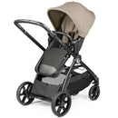 Single-to-double stroller in Vanilla Blend featuring a tan canopy, adjustable seat, and spacious storage basket.