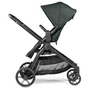 Single-to-double Peg Ypsi stroller in sage green with a canopy and black frame, featuring adjustable handlebars and a storage basket.