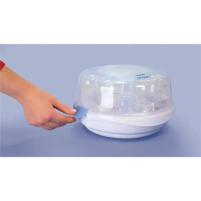 Avent Microwave Steam Sterilizer with a person using a blue tab to open the transparent lid, revealing bottles inside.