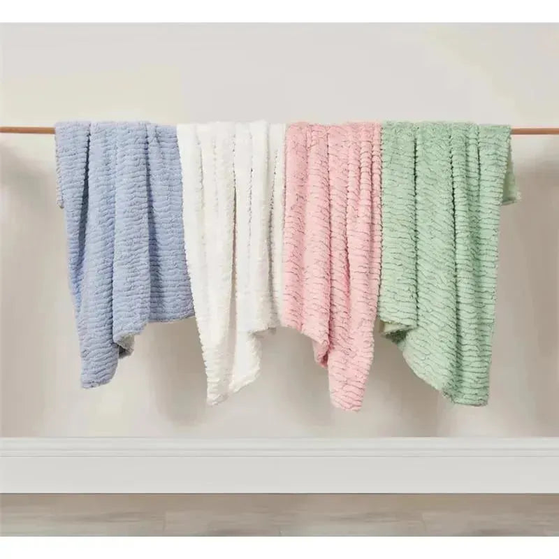Textured faux fur stroller blankets in blue, white, pink, and green, displayed on a wooden hanger against a neutral background.