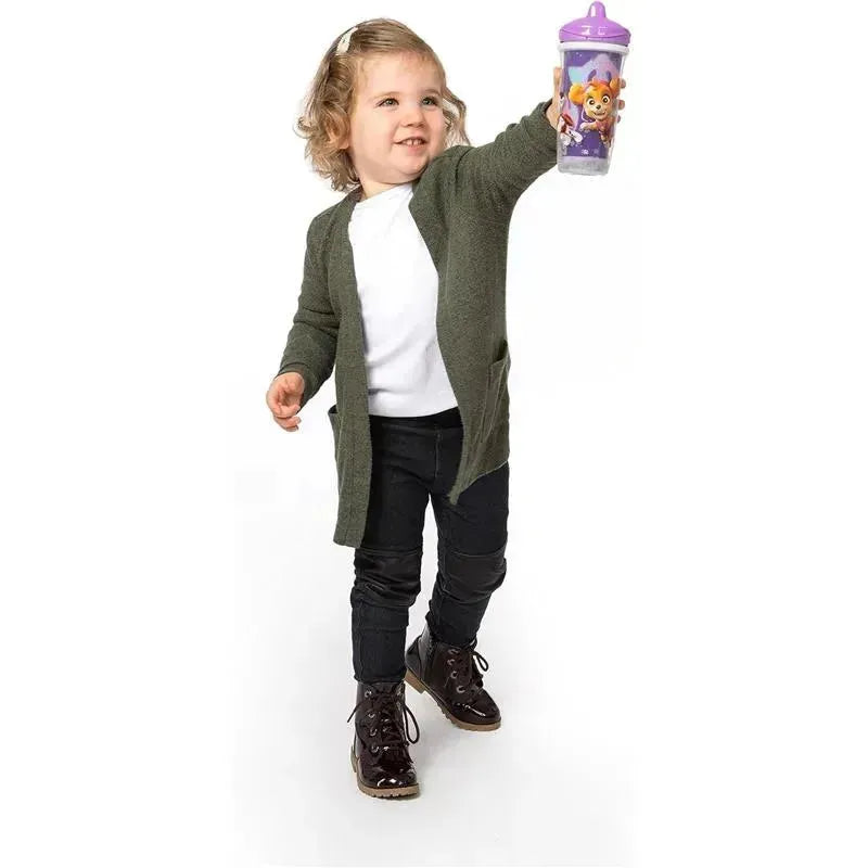 Toddler with short, curly hair wearing a green cardigan holds up a purple PAW Patrol sippy cup, smiling.