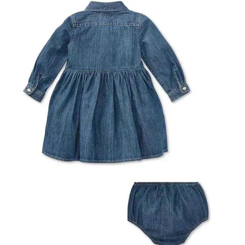 Shirred denim shirtdress in indigo for babies, featuring long sleeves and a flared skirt, accompanied by matching bloomers.