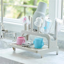 Gray drying rack holding colorful cups and lids, showcasing its use for drying dishes efficiently.
