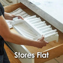 Gray drying rack being held above a wooden drawer, showcasing its flat storage capability.