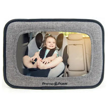 Baby car mirror showing a smiling infant in a rear-facing car seat, framed in a black melange design by Primo Passi.