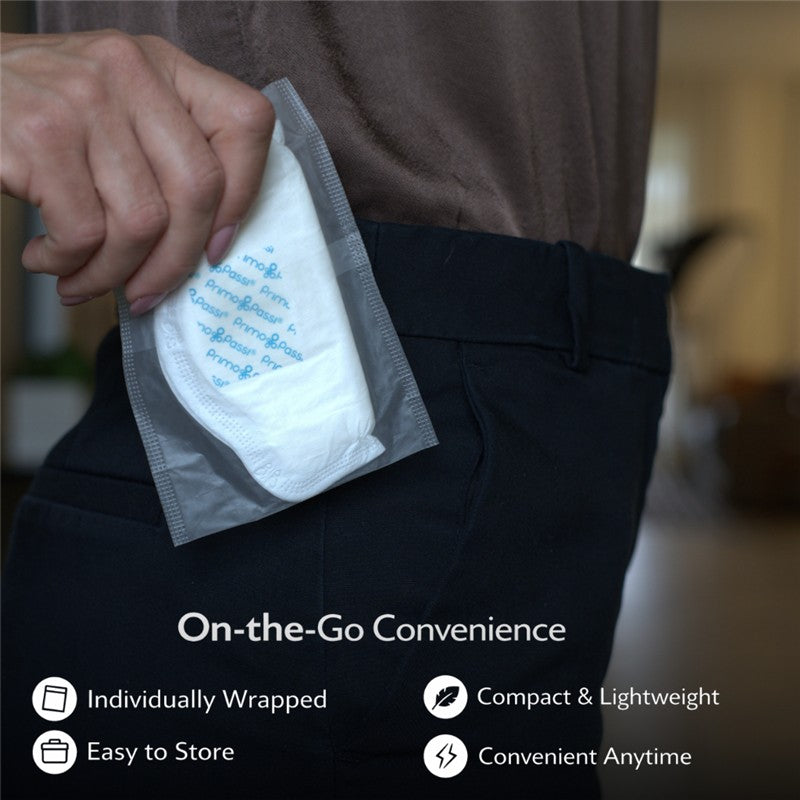 Primo Passi Disposable Nursing Breast Pad being pulled from a pocket, highlighting its individual packaging and convenience.