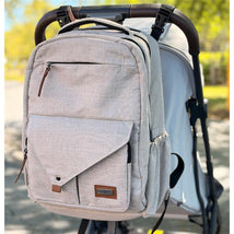 Beige Primo Passi PerTutti baby diaper bag backpack, featuring multiple pockets, zipper closures, and a front flap.