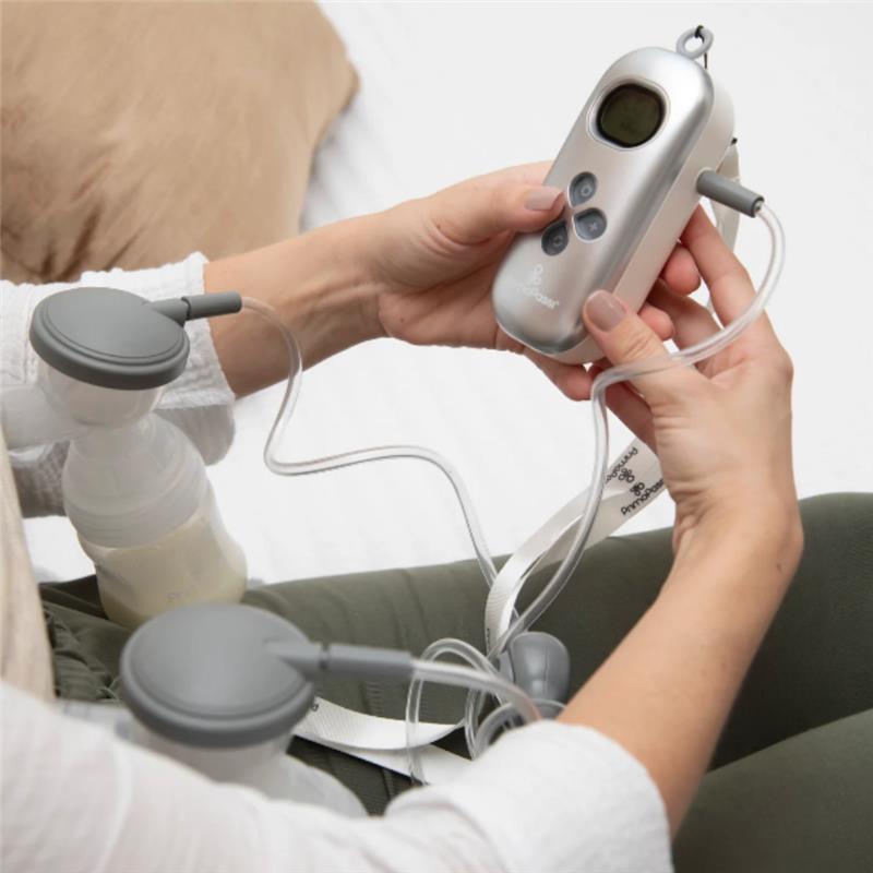 Portable dual-charge electric breast pump with display, tubing, and collection bottles in use.