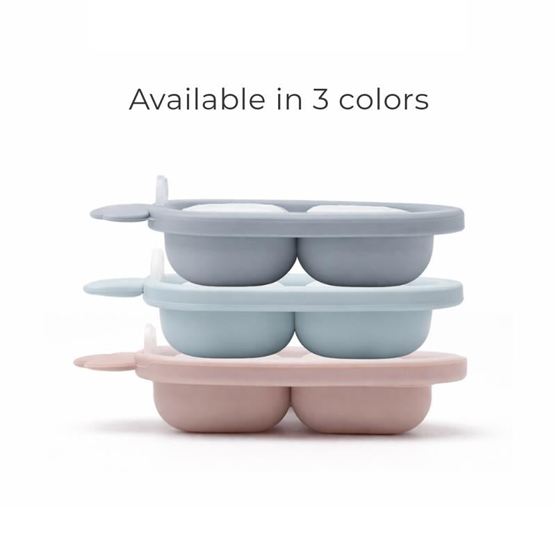 Silicone carrot freezer tray in dusty blue, displayed in a stack with pink and light blue variations, featuring four compartments.