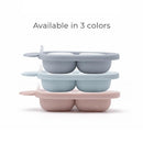Silicone carrot freezer tray in dusty blue, displayed in a stack with pink and light blue variations, featuring four compartments.