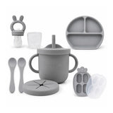 Silicone feeding set in senior grey, including a training cup, suction bowl, plate, spoons, and freezer container.