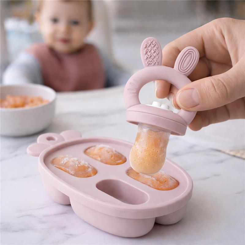 Primo Passi silicone food feeder in rose pink being used to feed a baby, featuring frozen food in a bunny-shaped design.