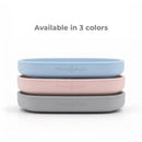 Primo Passi Silicone Suction Plates in blue, rose pink, and gray stacked, highlighting their availability in three colors.