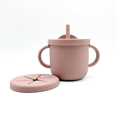 Silicone training cup and snack cup in rose pink with handles and a matching lid, featuring a cut-out design.
