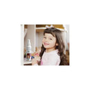 A smiling girl with long hair holds a doll while a Magic Detangler Conditioner bottle is visible beside her.