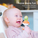 Baby happily using a Quark Fruuti Baby Fruit Feeder, exploring new tastes with a green food piece in the feeder.