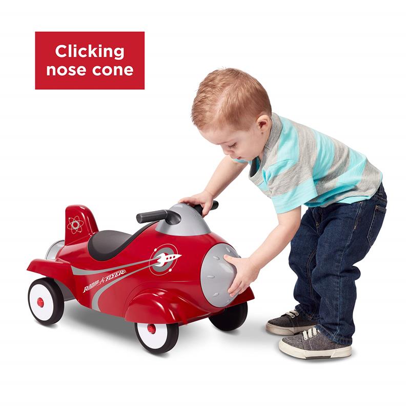 Child interacts with a red Radio Flyer retro rocket ride-on toy, featuring a clickable nose cone and push car design.