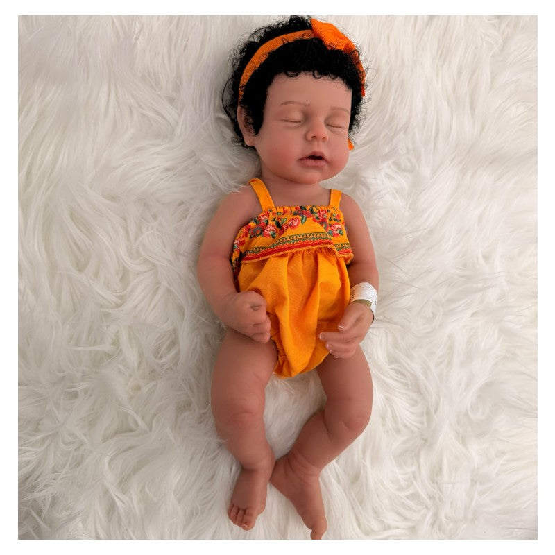 Reborn baby doll named Arianna, featuring African American traits, dressed in a bright orange outfit with floral accents.