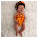 Reborn baby doll named Arianna, featuring African American traits, dressed in a bright orange outfit with floral accents.