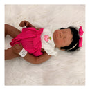 Reborn baby doll named Emily, featuring closed eyes, dark curly hair, wearing a pink outfit with a cherry design.