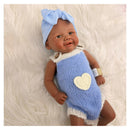 Bald African American reborn baby doll dressed in a blue knitted outfit with a heart design and a blue headband.