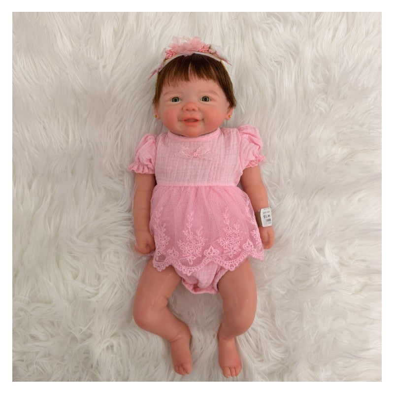 Reborn baby doll Vivienne, featuring a full silicone body, dressed in a pink outfit with lace detailing and a matching headband.