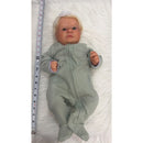 Reborn baby doll dressed in a green onesie with a matching headband, showing realistic facial features.