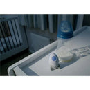 Portable sound-soother Rockit beside a baby bottle on a bedside table in a softly lit nursery.