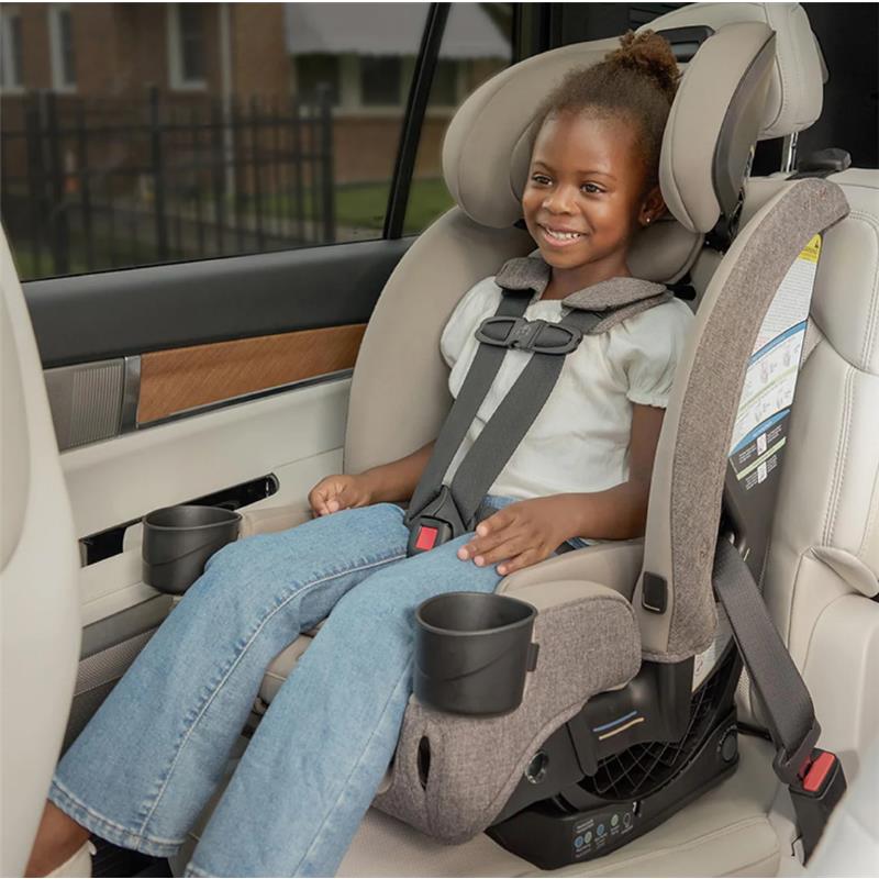 Romer Nexa All-in-One Convertible Car Seat in Truffle with a smiling girl seated securely, featuring cup holders and adjustable harness.