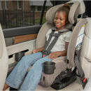 Romer Nexa All-in-One Convertible Car Seat in Truffle with a smiling girl seated securely, featuring cup holders and adjustable harness.