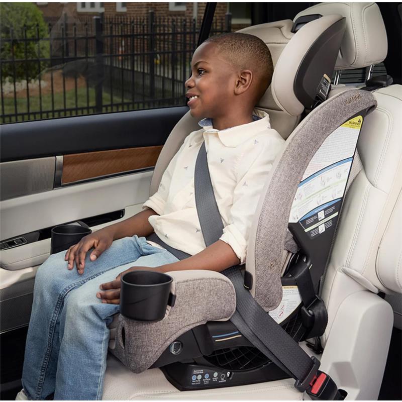 Romer Nexa All-in-One Convertible Car Seat in Truffle fabric, featuring a child securely seated with seatbelt and cup holders.