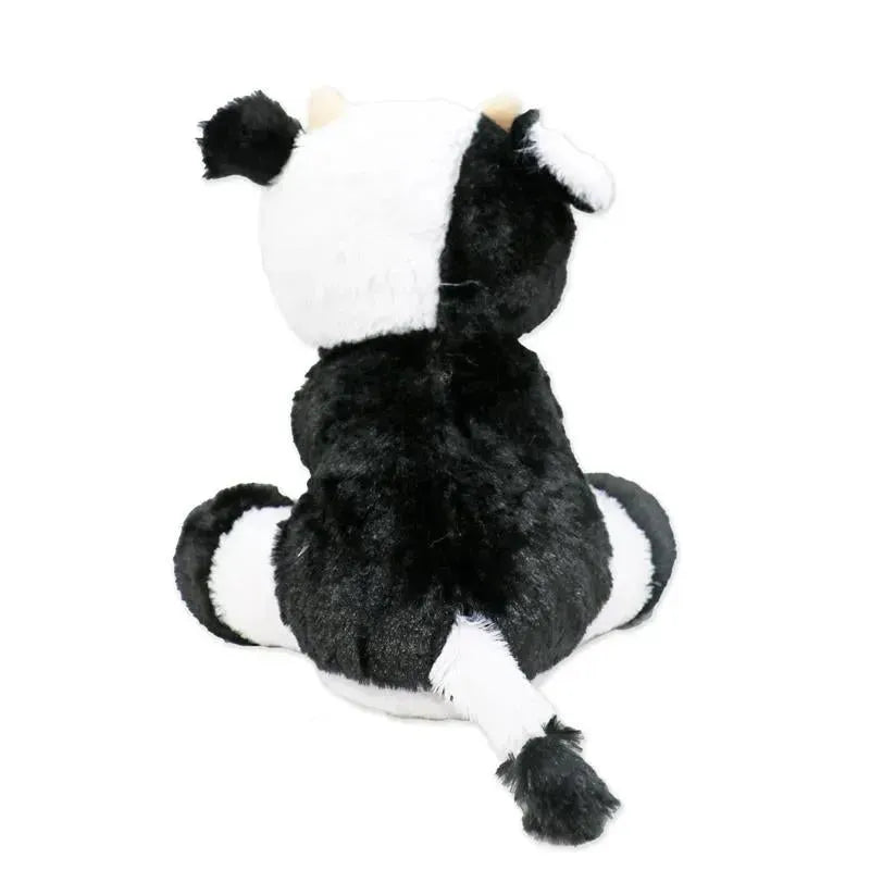 Plush toy cow with a black and white pattern, seated with a tail and ears visible from the back.