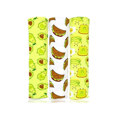 Three knit swaddles in a pack featuring avocado, taco, and cartoon food designs on bright backgrounds.