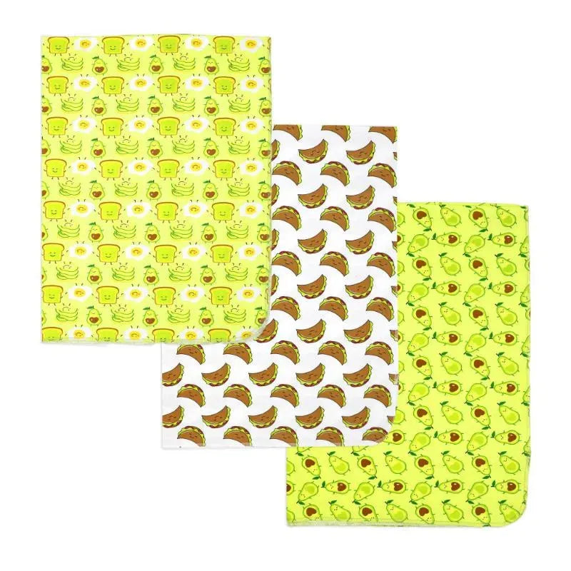 Three knit swaddles featuring avocado-themed patterns: smiling avocados, bananas, and green designs.