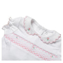 Short-sleeve white baby girl top with a scalloped collar, pink floral embroidery, and smocking detail across the front.