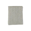 Grey cable knit blanket folded neatly, featuring a textured pattern of cables running vertically.