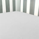 Solid grey flannel crib sheet fitted snugly on a crib mattress, surrounded by white crib slats.