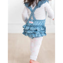 Light wash flutter overall romper for baby girl with ruffled skirt, worn over white leggings with pink bows.