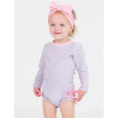 Baby girl wearing a lavender seersucker long sleeve one-piece rash guard with pink accents, smiling and looking at the camera.