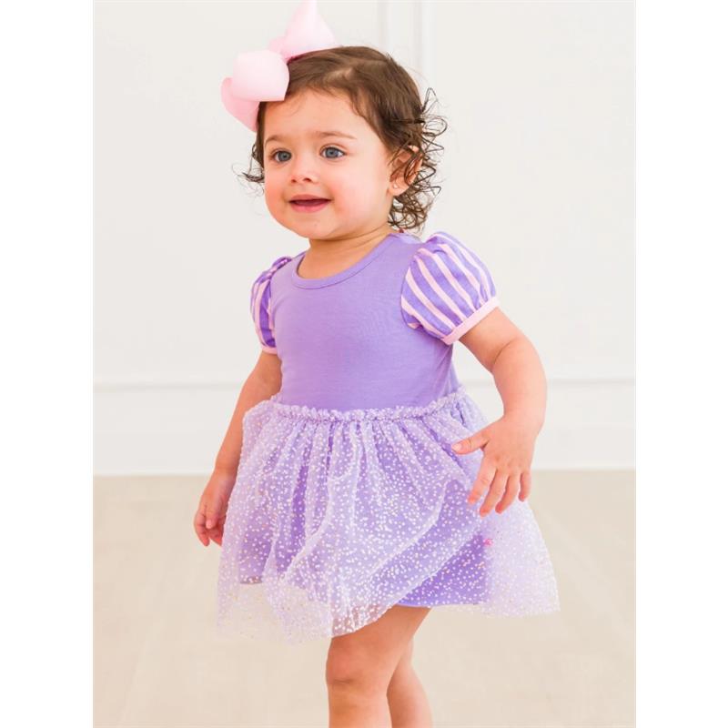 Baby girl in a purple short sleeve romper with striped puff sleeves and a tulle skirt, smiling and standing.