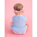 Long sleeve periwinkle blue seersucker swimsuit for girls, featuring a bow peplum and a back zipper, worn by a seated baby.