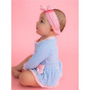 Long sleeve periwinkle blue seersucker swimsuit with a bow peplum detail, worn by a baby girl with a pink headband.