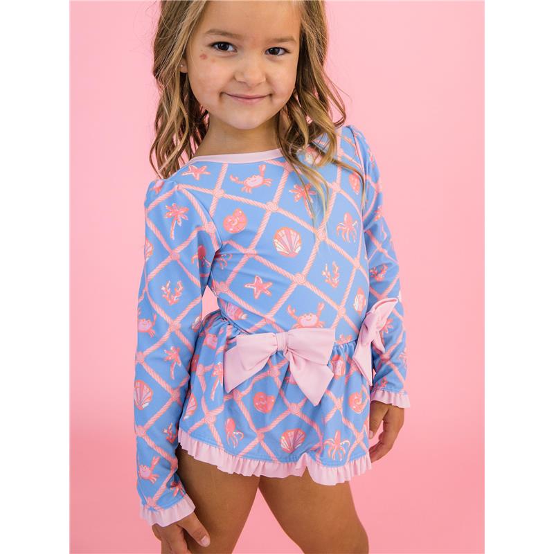 Girls tropical-themed long sleeve swimsuit in blue with pink shell and crab patterns, featuring a bow peplum and ruffled hem.