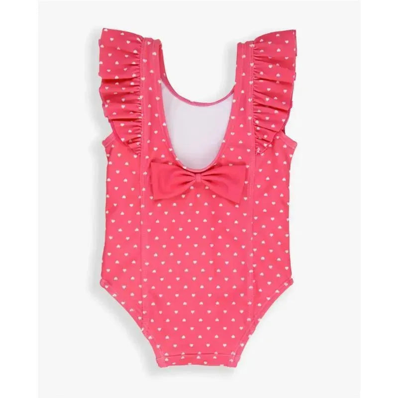 Hot pink one-piece swimsuit with white heart patterns, ruffled sleeves, and a large bow detail at the front.