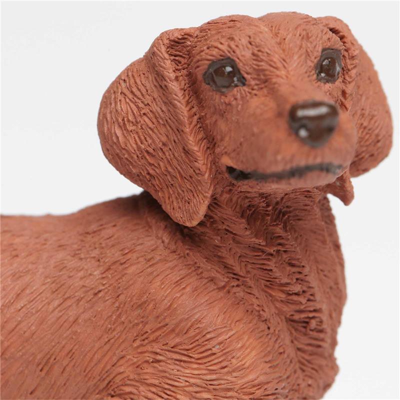 Dachshund figurine made of plastic, featuring textured fur details and a smiling expression, measuring 3.75 inches.