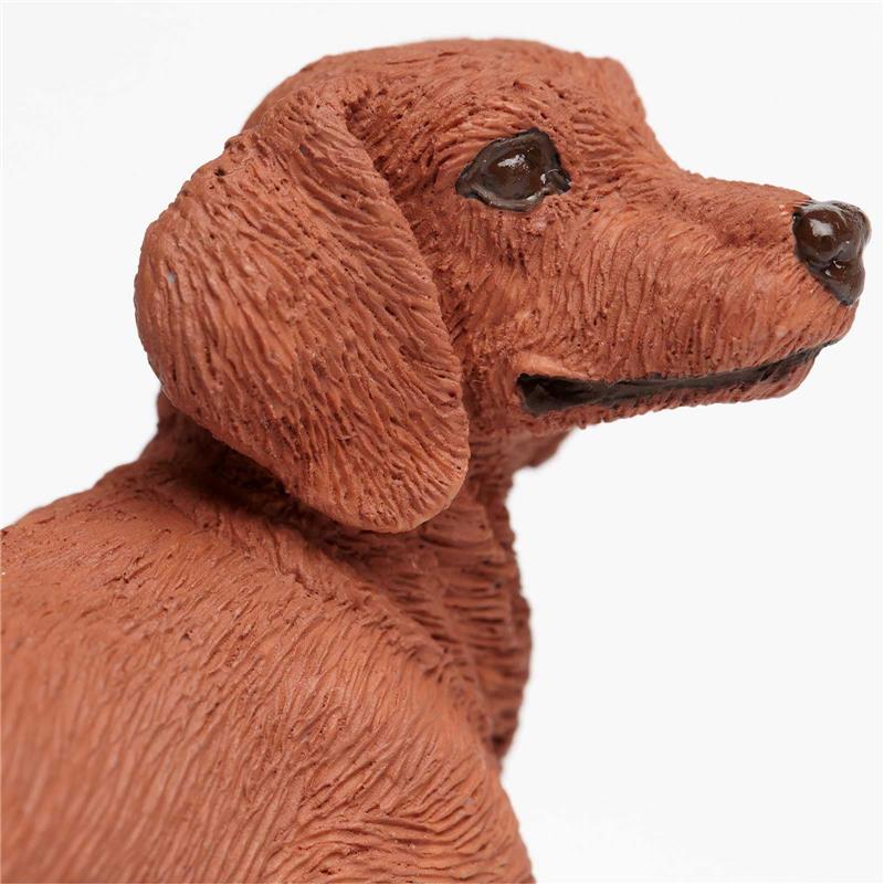 Dachshund figurine in brown plastic, featuring detailed fur texture and realistic facial features.